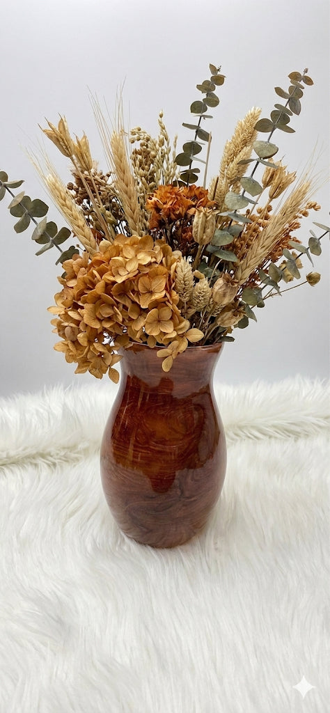 Brown vase with dried flowers on a white fur surface