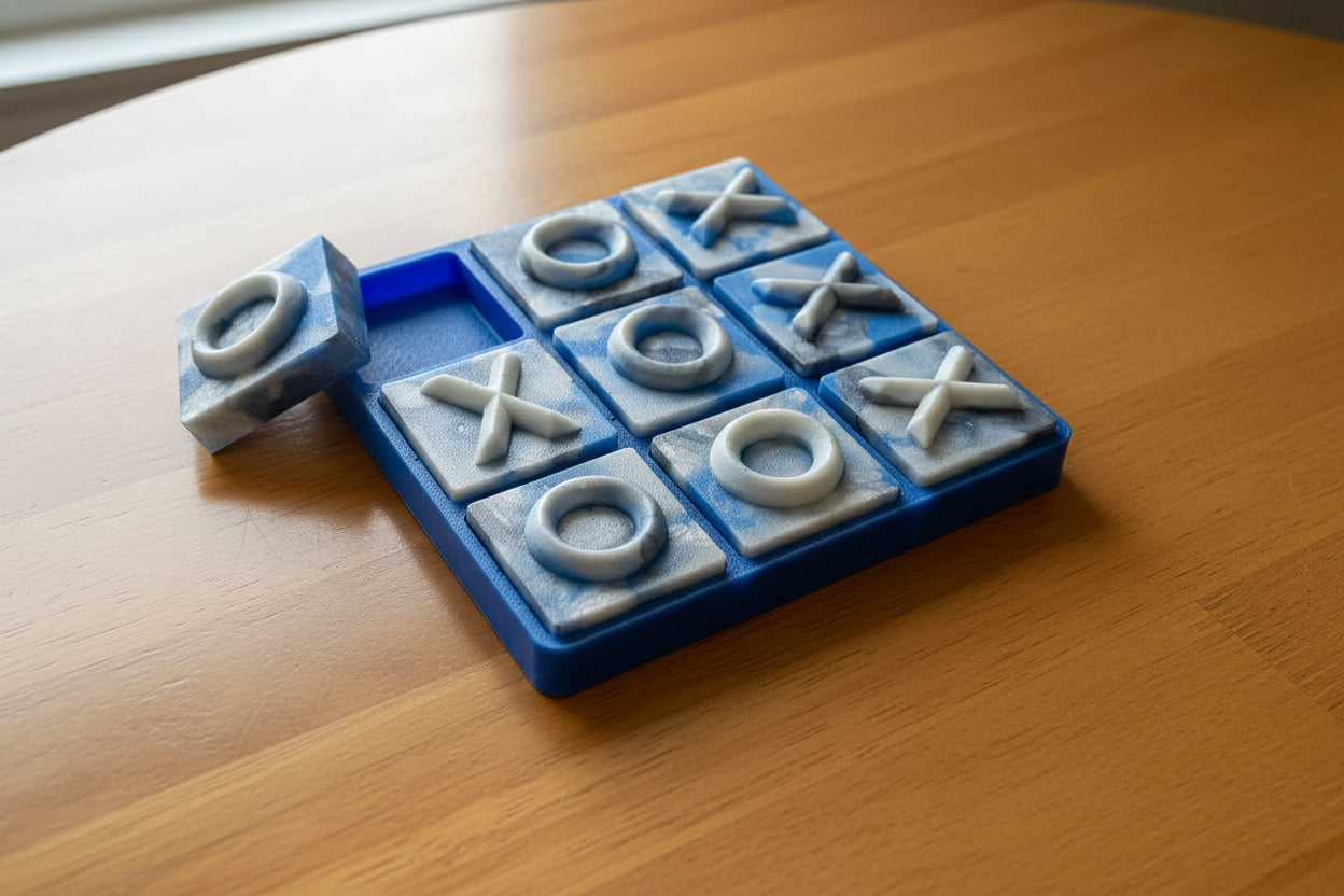 A blue square tic tac toe, filled with marbled blue and white pigmented resin colors. 