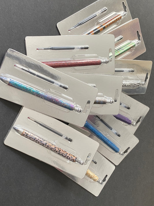 A collection of custom resin pens in various colors, displayed in individual packaging.