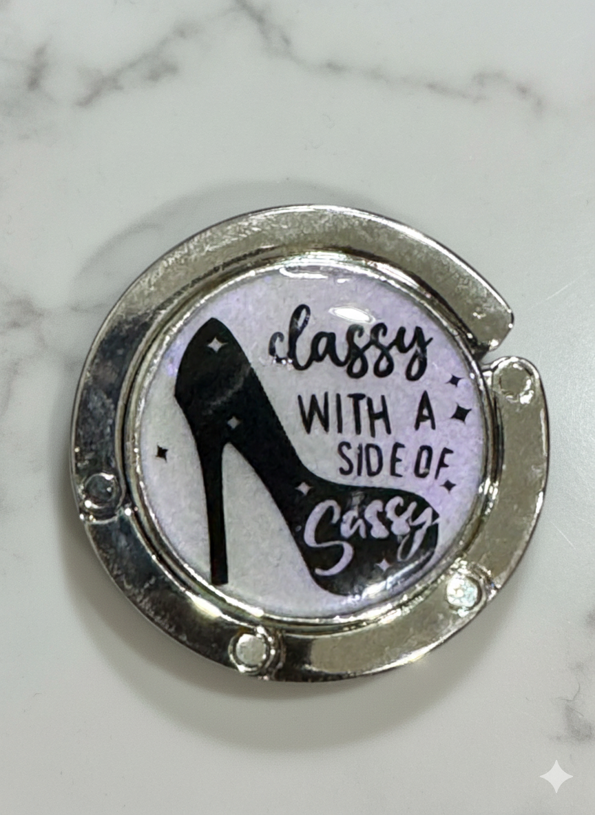 Silver ring with high heel design and text on a marble background