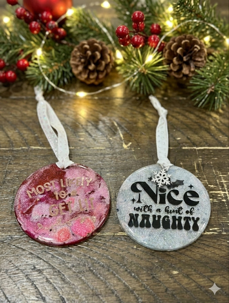 Two Christmas ornaments with text on a wooden surface with festive background