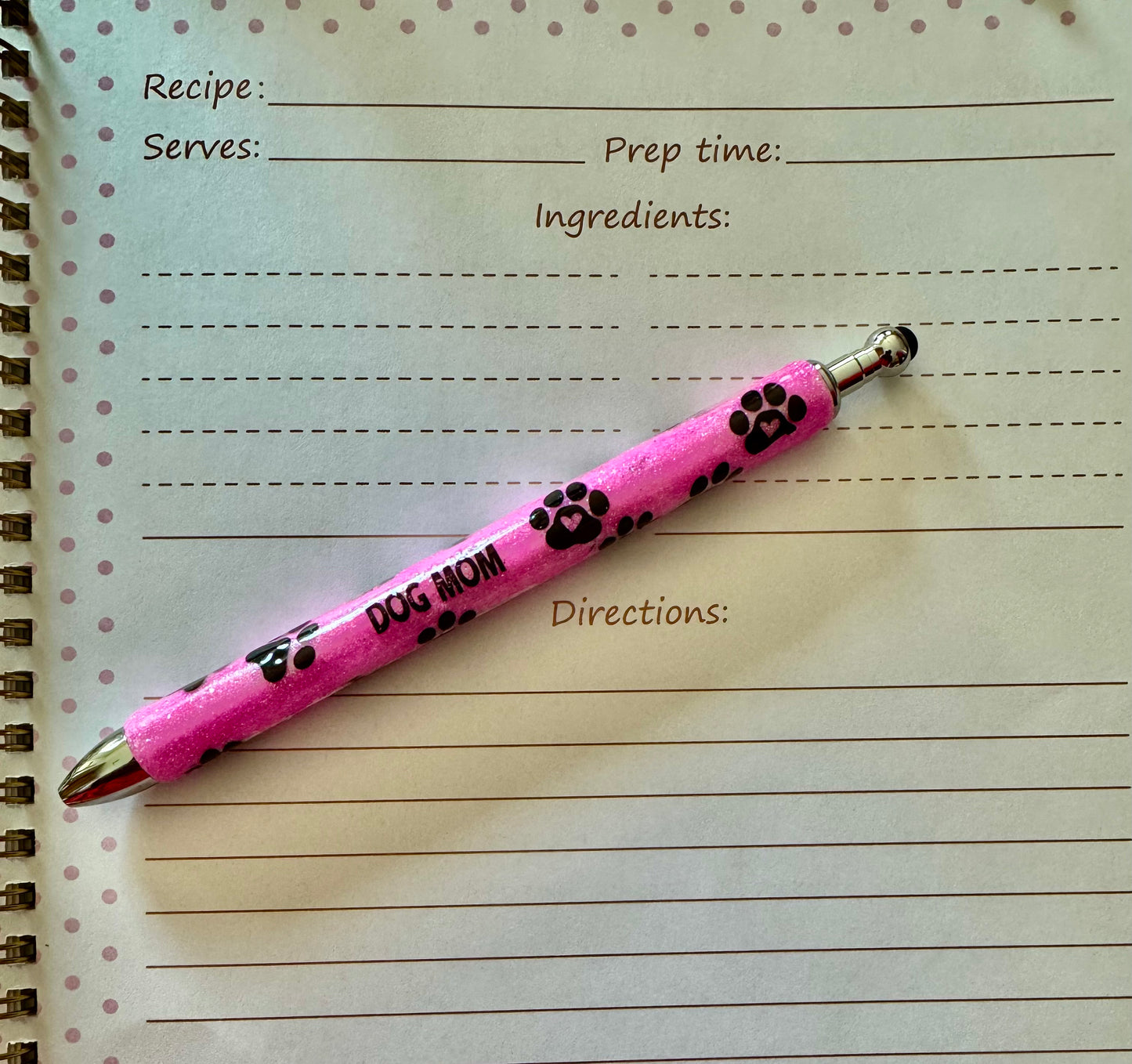 Pink pen with paw prints on a recipe book page