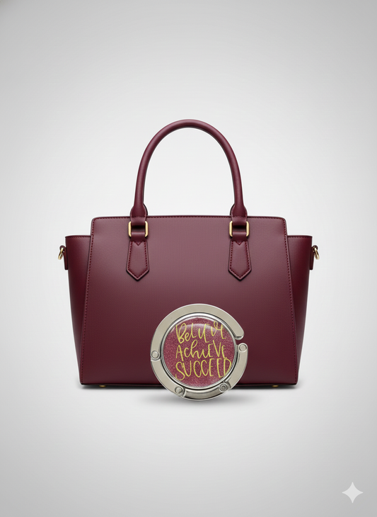 Maroon handbag with a circular emblem on a light gray background