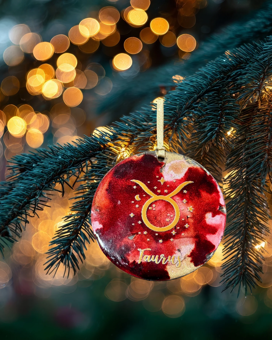Decorative Taurus zodiac ornament on a Christmas tree with blurred lights in the background