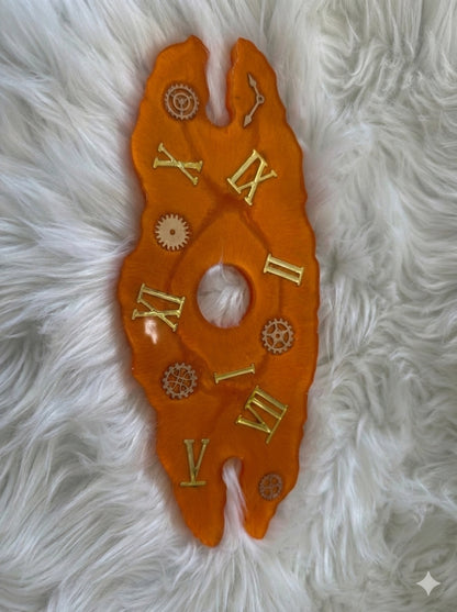 Decorative orange clock face wine caddy with Roman numerals on a white fluffy surface