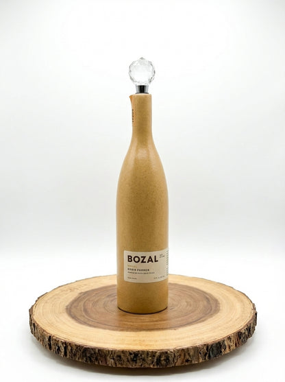 Wooden wine bottle-shaped object with a label on a wooden coaster against a white background