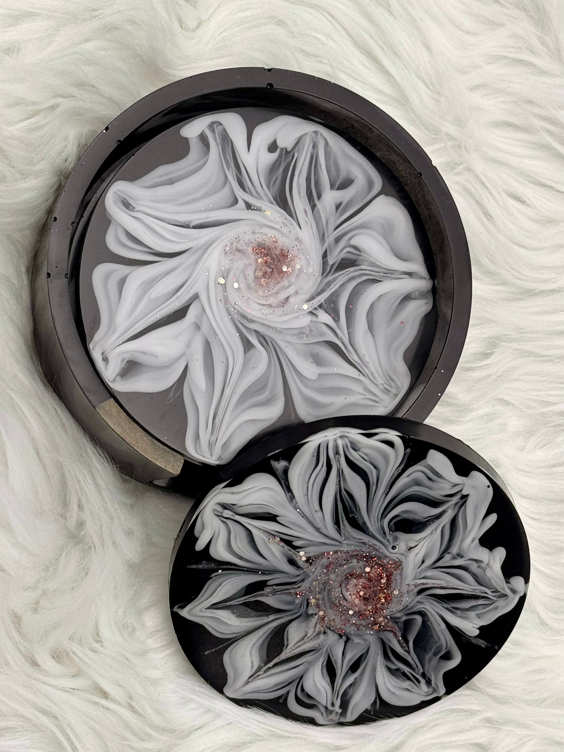 Set of four coasters, black with a white flower and a glitter center