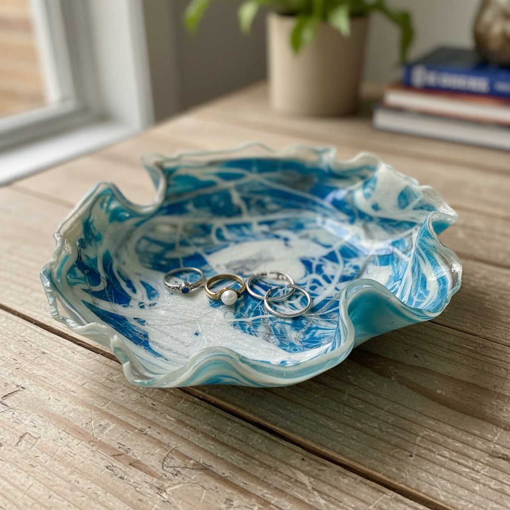 A ruffled-edge glass bowl with a marbled blue and white pattern, photographed from above on a white faux fur background.